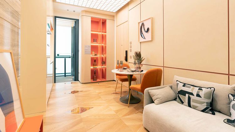 客廳牆身以石材搭配藝術油漆打造而成，天花裝設軸線分明、具現代感的燈箱令空間質感昇華。